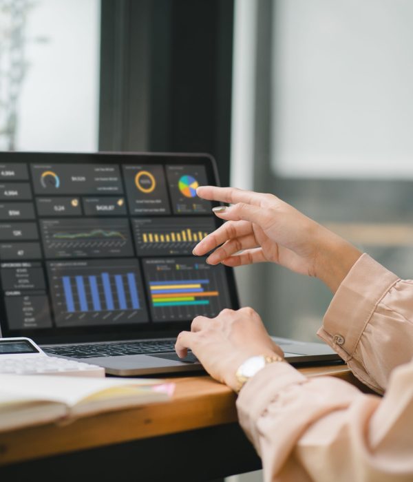 The female analyst utilizes a computer and a dashboard for business data analyze and a data management system with KPI. The concepts of technology, finance, operations, sales, and marketing